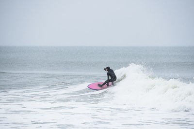 Man surfing in sea against sky