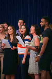 Multi-ethnic people singing in choir on school stage