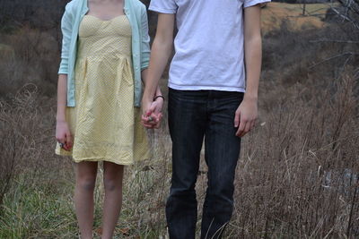 Midsection of couple standing on field