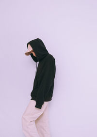 Side view of woman standing against white background