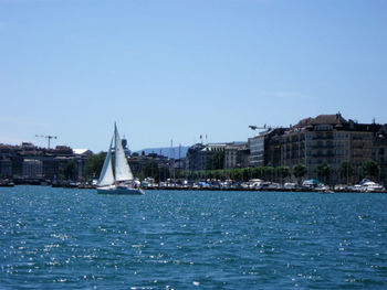 Sailboat floating on river against clear sky