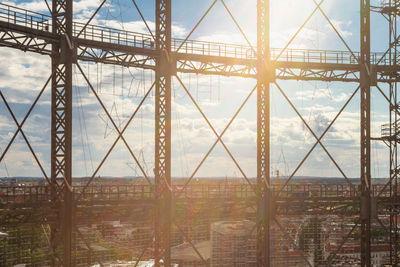 Bridge over river in city against sky