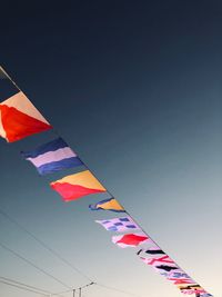 Low angle view of flags against clear sky