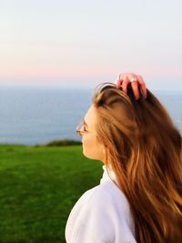 Woman looking at sea shore against sky