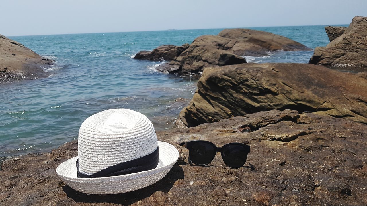 sea, water, horizon over water, beach, nature, beauty in nature, scenics, rock - object, tranquil scene, tranquility, no people, day, sand, sun hat, outdoors, clear sky, sky