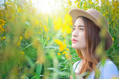 Young woman wearing hat while standing on field