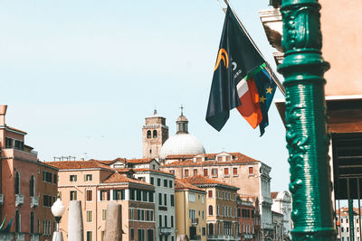 Low angle view of flags hanging against buildings in city