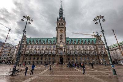 Group of people in front of historical building against sky