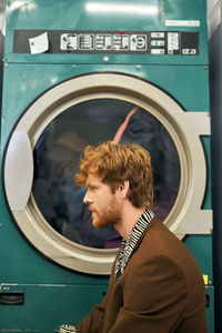 Portrait of young man looking through window