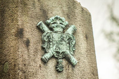 Close-up of old statue against wall