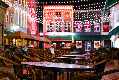 Empty chairs and tables in restaurant at night