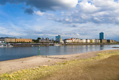 River by buildings against sky in city