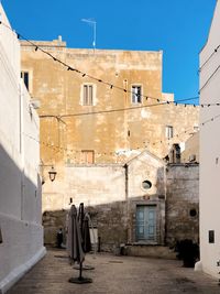 Clothes drying on alley amidst buildings in city