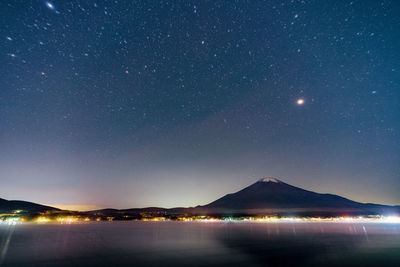 Scenic view of illuminated mountains against sky at night