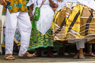 Lower part of candomble members dressed in traditional clothes for religious festival