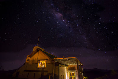 Illuminated house against star field