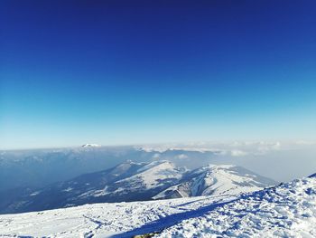 Scenic view of snowcapped mountains against blue sky