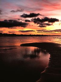 Scenic view of sea against dramatic sky during sunset