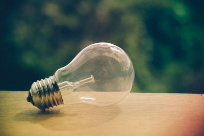 Close-up of light bulb on table