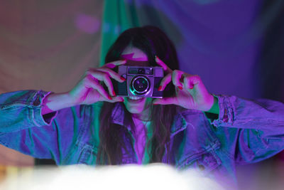 Woman photographing in blue lighting