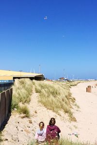 Woman on beach against clear blue sky