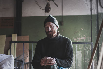 Smiling man wearing knit hat sitting indoors