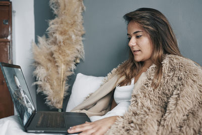 Young woman talking to doctor on video call at home