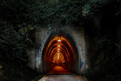 Illuminated tunnel at night