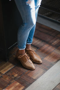 Low section of woman standing on hardwood floor