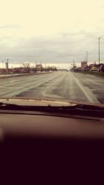 Cars on road against cloudy sky