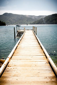 Wooden pier on jetty leading towards lake