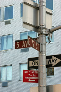 Low angle view of road sign against building