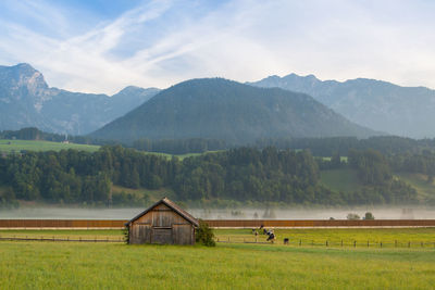 Scenic view of agricultural field by mountains against sky