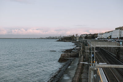 Bridge over sea against sky during sunset