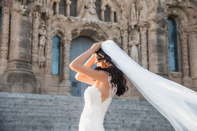 Woman standing against built structure