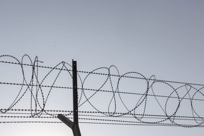 Silhouette image of barbwire fence in sunny day