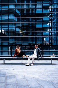 Man and woman sitting on seat in building