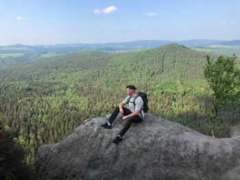 Young man sitting on mountain