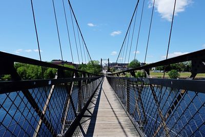 Bridge over footbridge against blue sky