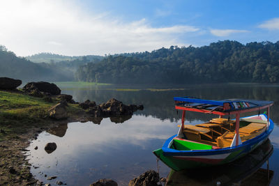 Boats moored in lake against sky