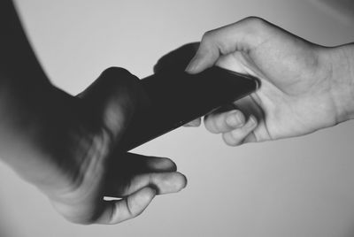 Close-up of hand holding hands over white background