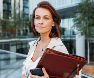 Portrait of young woman using digital tablet in city