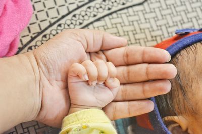 Close-up of baby hand holding hands