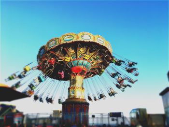 Low angle view of carousel against clear sky