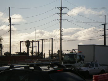 Cars on road against cloudy sky