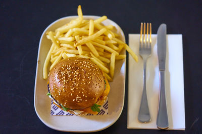 Close-up of burger and french fries in bowl on table