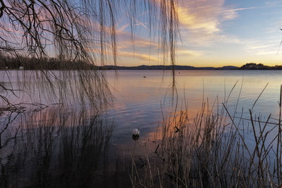 Scenic view of lake against sky at sunset