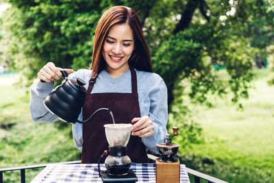 Smiling young woman holding coffee