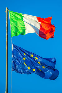 Low angle view of flag against blue sky