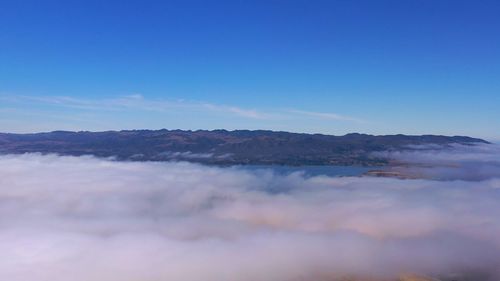 Scenic view of mountains against blue sky